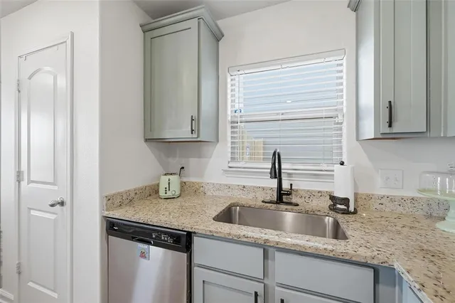 a kitchen with granite countertop a sink and cabinets