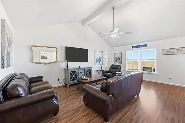 a living room with furniture a ceiling fan and a flat screen tv