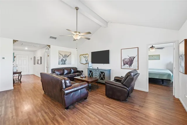 a living room with furniture flat screen tv and wooden floor