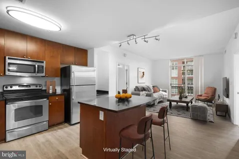 a living room with stainless steel appliances granite countertop furniture a fireplace a rug and a window