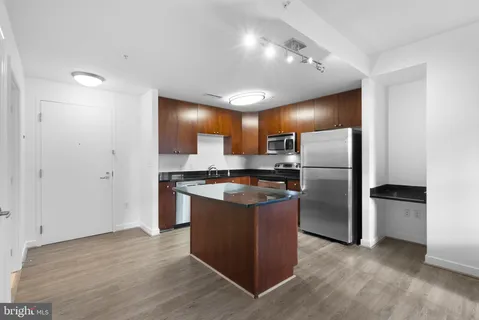 a kitchen with stainless steel appliances granite countertop a refrigerator and a stove