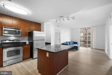 a kitchen with stainless steel appliances granite countertop a refrigerator a stove and a sink with cabinets