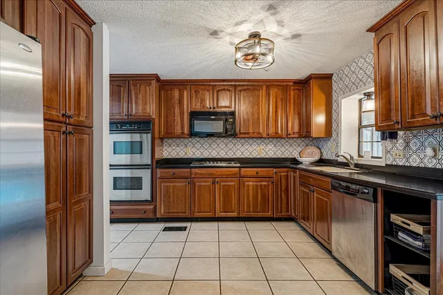 a kitchen with stainless steel appliances granite countertop a refrigerator and a sink