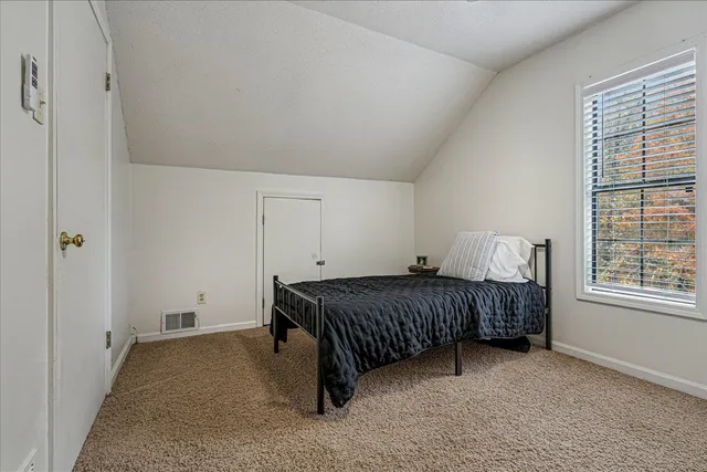 a bedroom with a bed table and a window