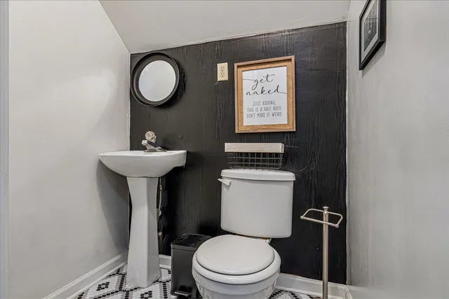 a bathroom with a toilet sink and mirror