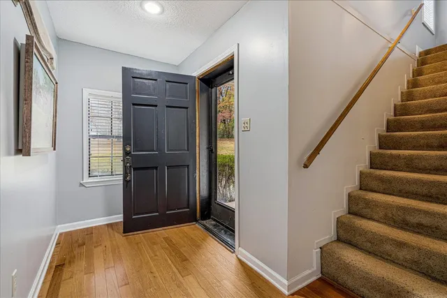a view of an entryway with wooden floor and door