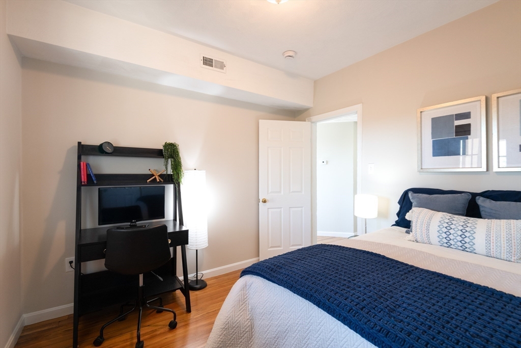 407 Washington Street, Unit 5 Boston, MA 02124 - Photo 13 of 24 a bedroom with a bed and a flat screen tv