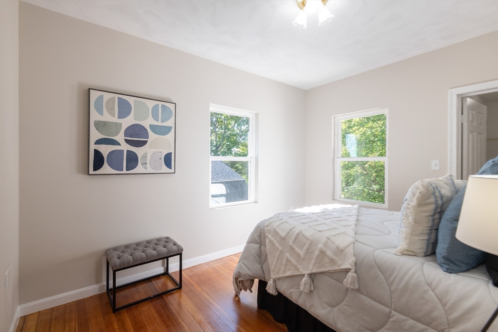 407 Washington Street, Unit 5 Boston, MA 02124 - Photo 19 of 24 a bedroom with a bed and a chair with window