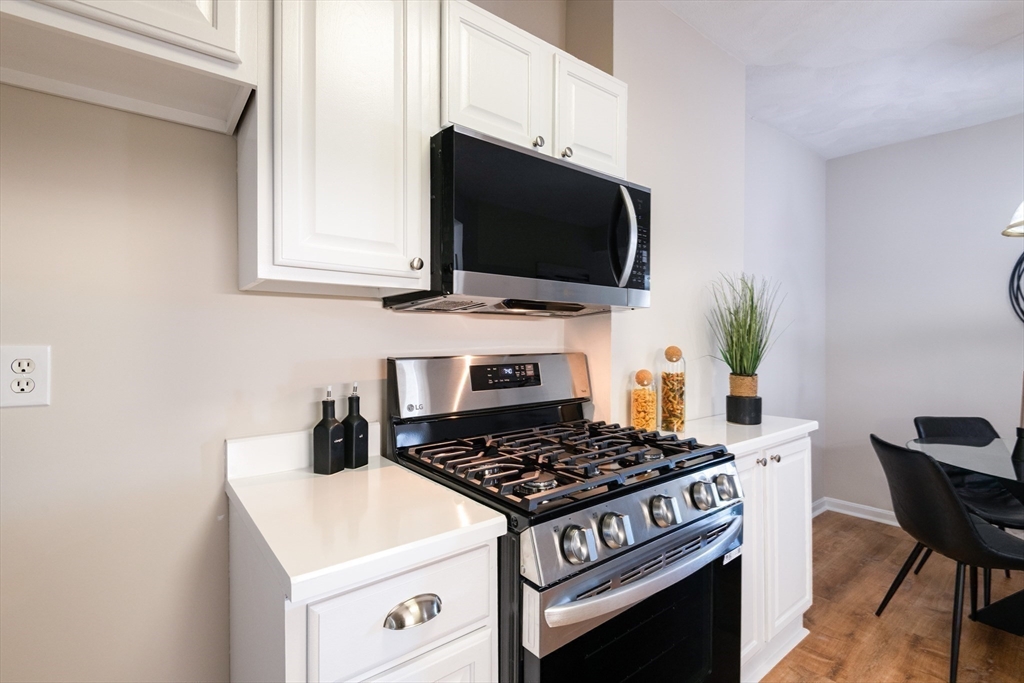 407 Washington Street, Unit 5 Boston, MA 02124 - Photo 3 of 24 a kitchen with a stove and a microwave