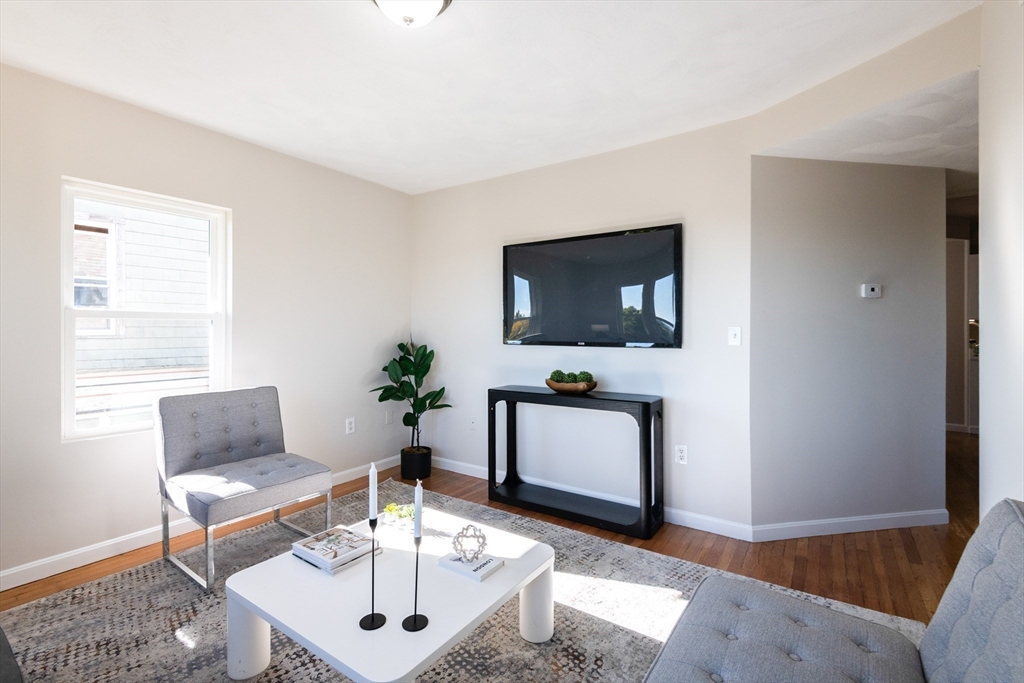 407 Washington Street, Unit 5 Boston, MA 02124 - Photo 6 of 24 a living room with furniture a flat screen tv and a window