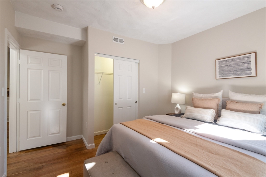 407 Washington Street, Unit 5 Boston, MA 02124 - Photo 10 of 24 a bedroom with a bed and wooden floor