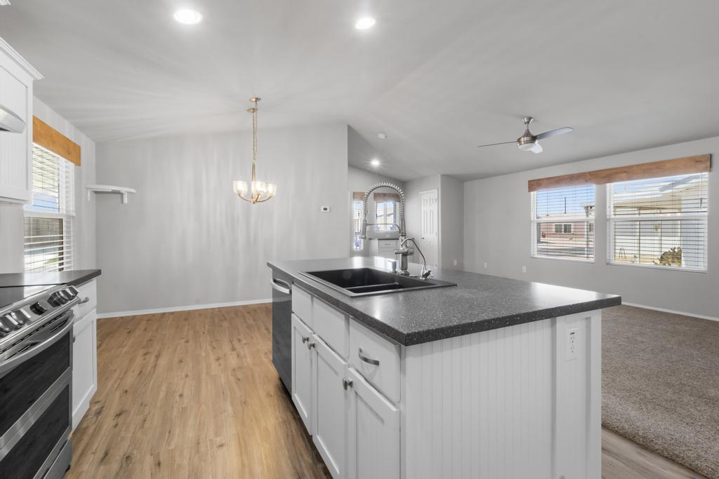1545 East El Rodeo Road, Unit 42 Fort Mohave, AZ 86426 - Photo 24 of 45 a kitchen with stainless steel appliances granite countertop a sink a stove and a wooden floors