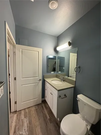 a bathroom with a granite countertop toilet sink and mirror