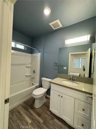 a bathroom with a double vanity sink toilet mirror and shower