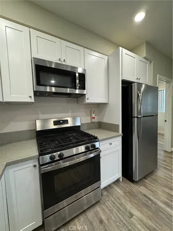 a kitchen with stainless steel appliances granite countertop a stove a refrigerator and a microwave