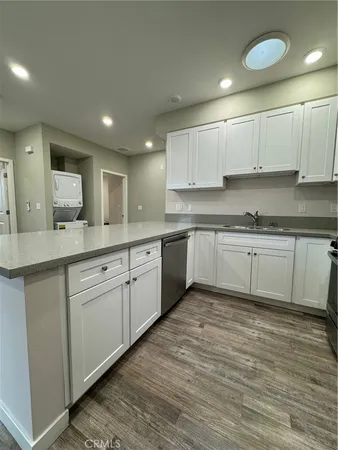 a kitchen with a sink cabinets and wooden floor
