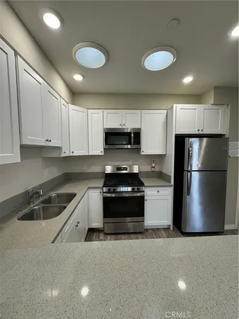 a kitchen with a refrigerator a stove a microwave and cabinets