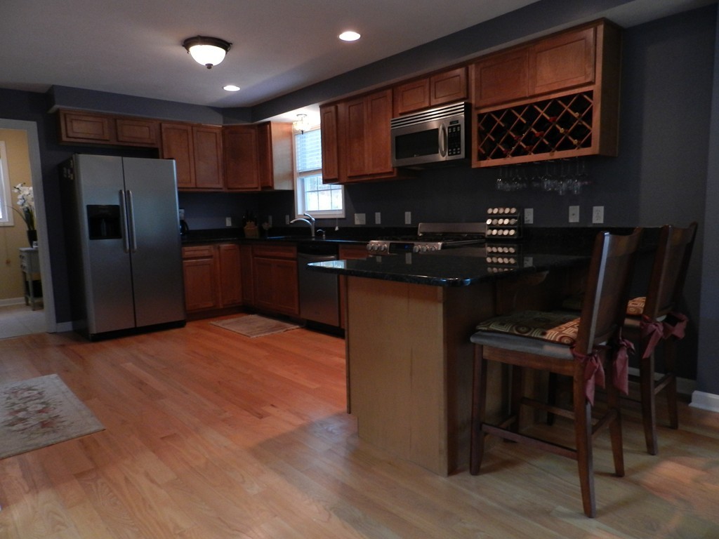 415 Mashapaug Road Holland, MA 01521 - Photo 7 of 26 a kitchen with stainless steel appliances granite countertop a refrigerator and a stove top oven