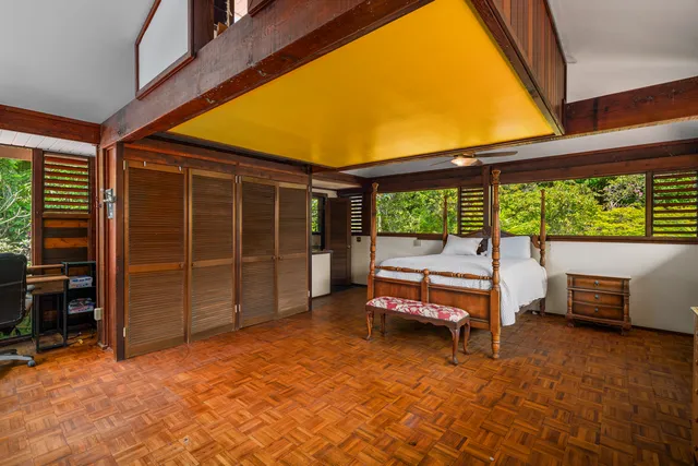 a bedroom with a bed and large windows