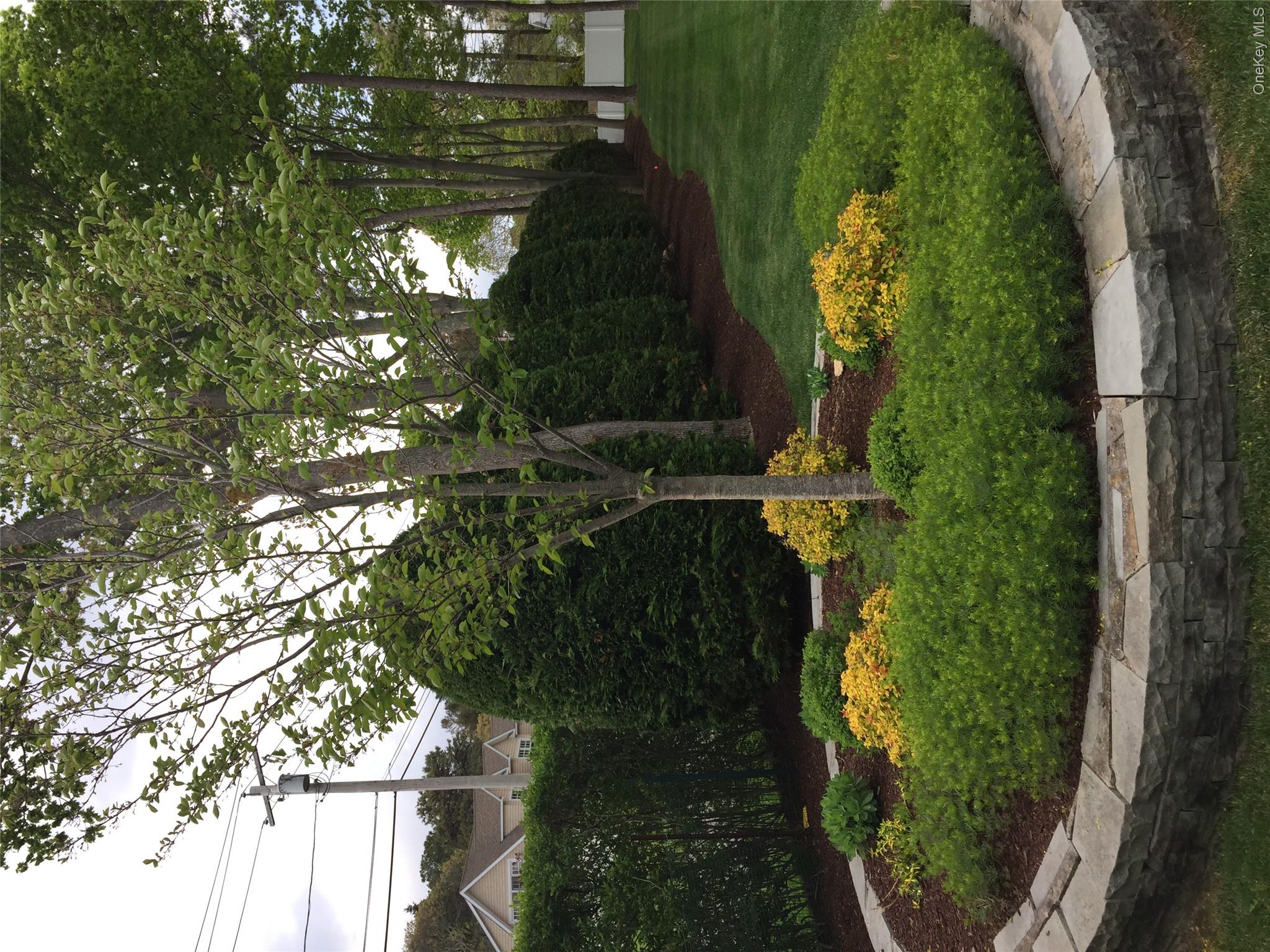 2 South Valley Road Hampton Bays, NY 11946 - Photo 14 of 19 a backyard of a house with lots of green space and fountain
