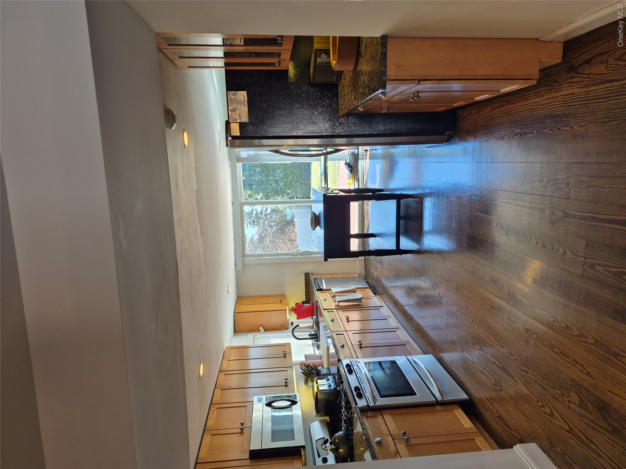 2 South Valley Road Hampton Bays, NY 11946 - Photo 6 of 19 a kitchen with granite countertop a refrigerator a stove top oven a sink dishwasher and wooden cabinets with wooden floor