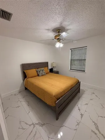 a bedroom with a bed and a ceiling fan