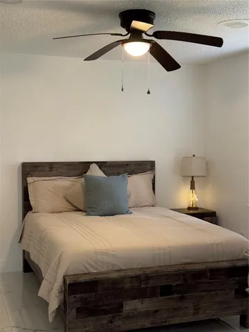 a bedroom with a bed and a ceiling fan