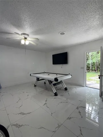 a living room with furniture and a ceiling fan