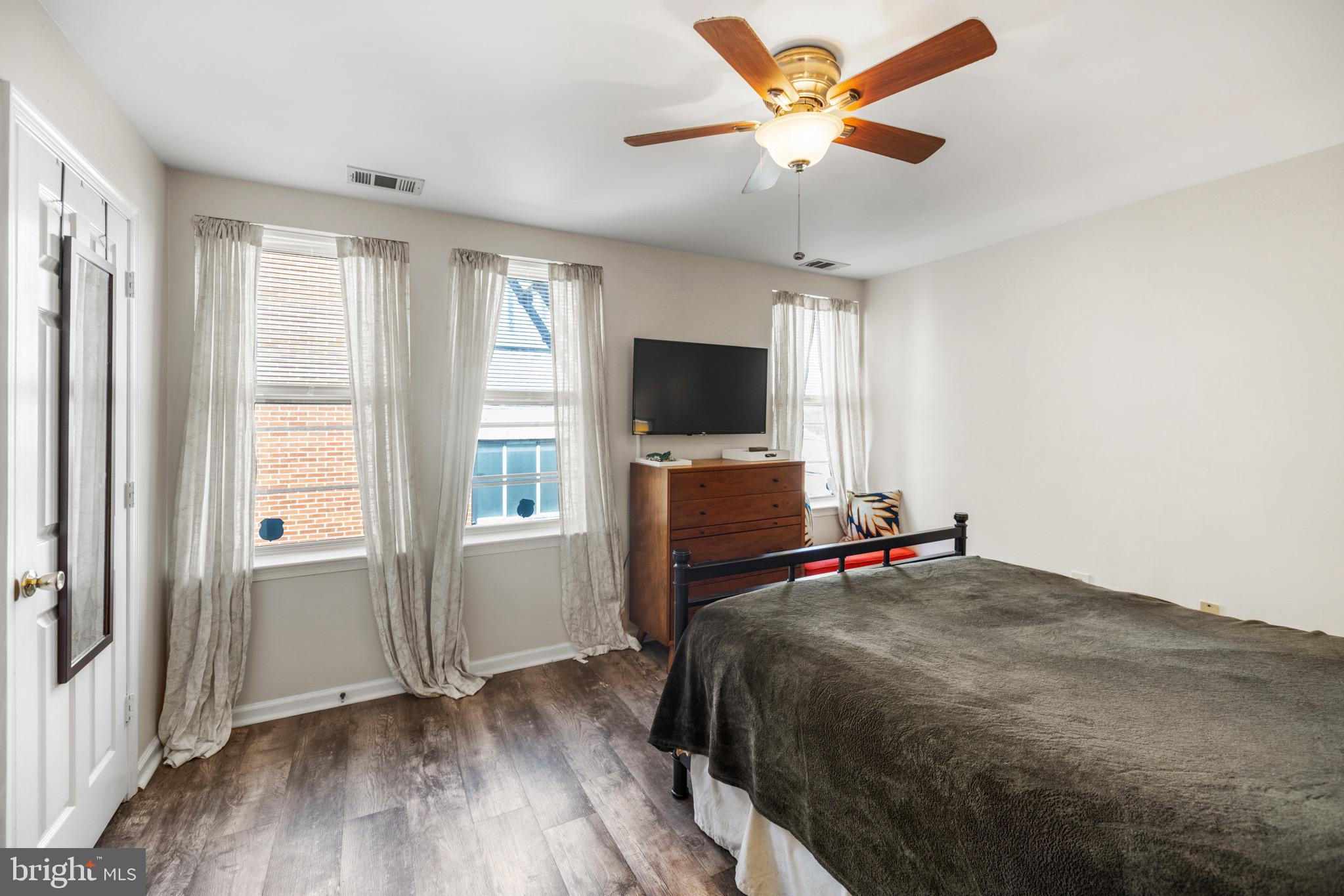 1210 Perry Street Northeast, Unit 201 Washington, DC 20017 - Photo 12 of 16 a bedroom with a bed and a flat screen tv