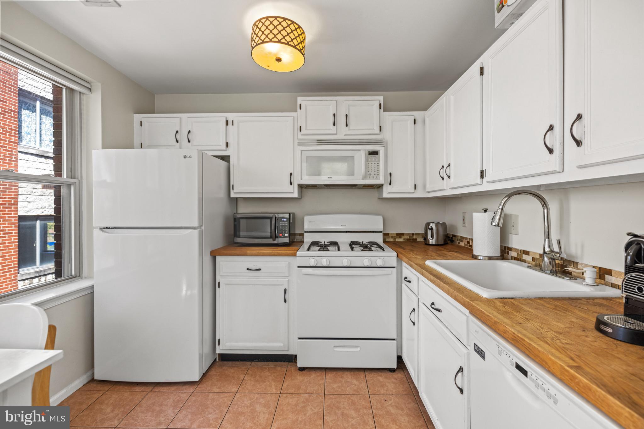 1210 Perry Street Northeast, Unit 201 Washington, DC 20017 - Photo 7 of 16 a kitchen with a white cabinets and white appliances