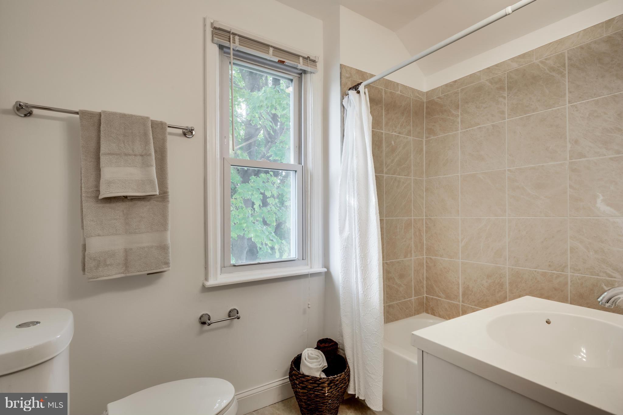 3202 Grace Road Baltimore, MD 21219 - Photo 14 of 29 a bathroom with a sink toilet a mirror and shower