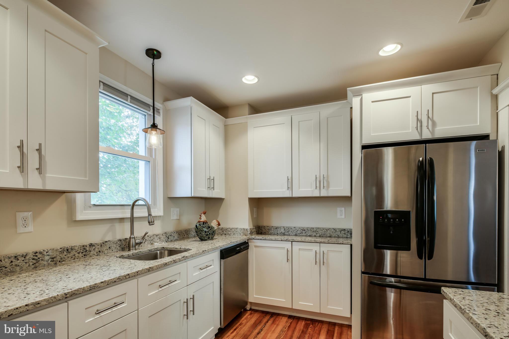 3202 Grace Road Baltimore, MD 21219 - Photo 8 of 29 a kitchen with stainless steel appliances granite countertop a refrigerator a sink dishwasher a stove and white cabinets with wooden floor