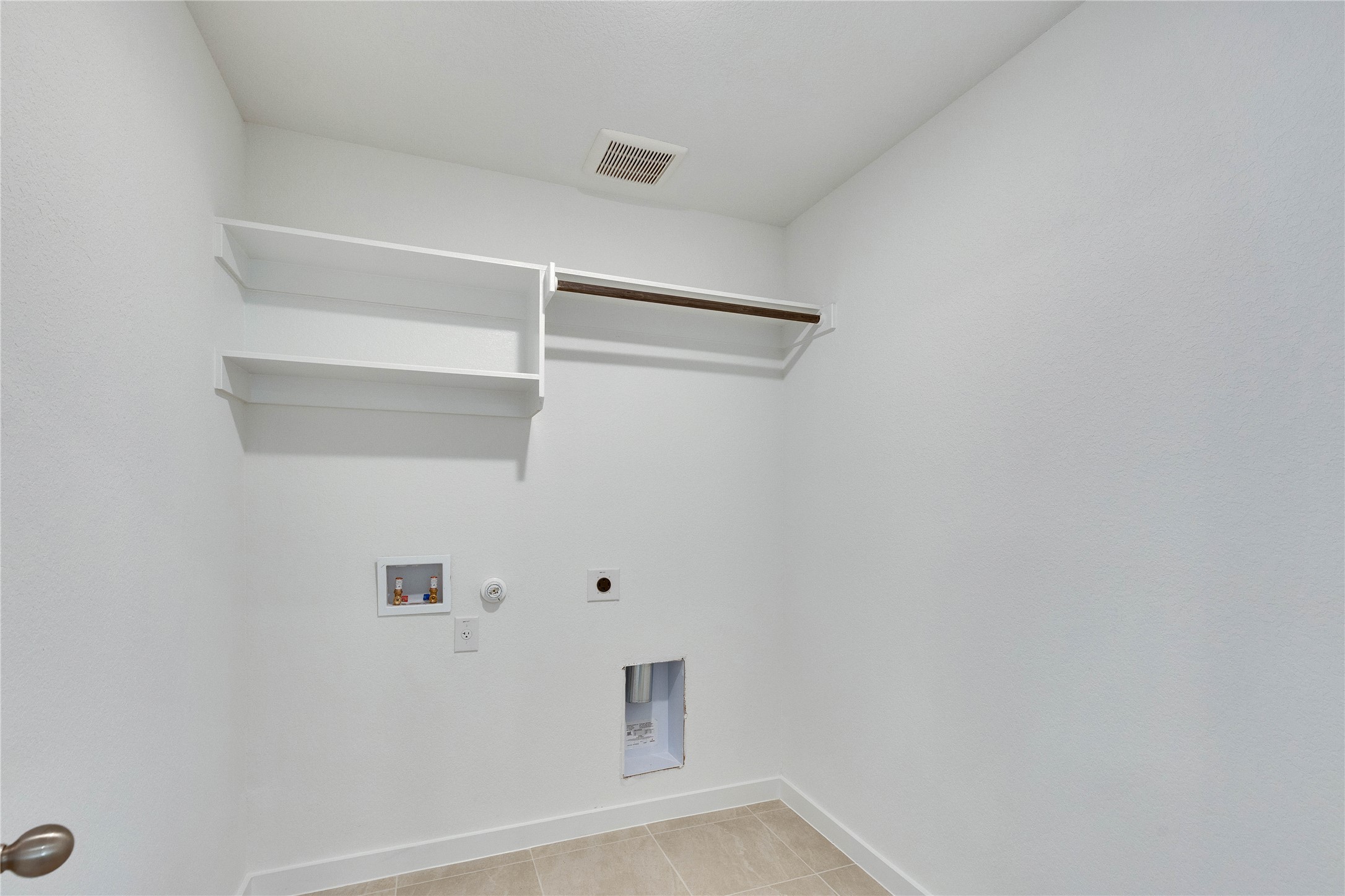 13509 Barn Chime Street Elgin, TX 78621 - Photo 40 of 40 Dedicated utility space featuring built-in shelving, a clothes rod, and tile flooring