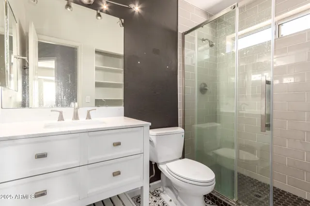 a bathroom with a sink toilet vanity and shower