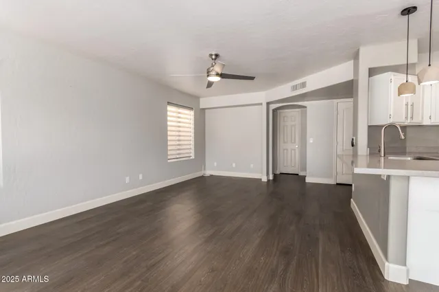 a view of a kitchen with wooden floor and a ceiling fan