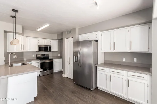 a kitchen with stainless steel appliances a refrigerator sink and microwave