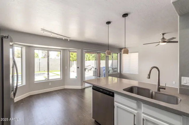 a kitchen with a large window a sink and living room view