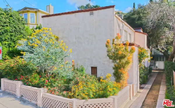 a view of a flower garden with wooden fence