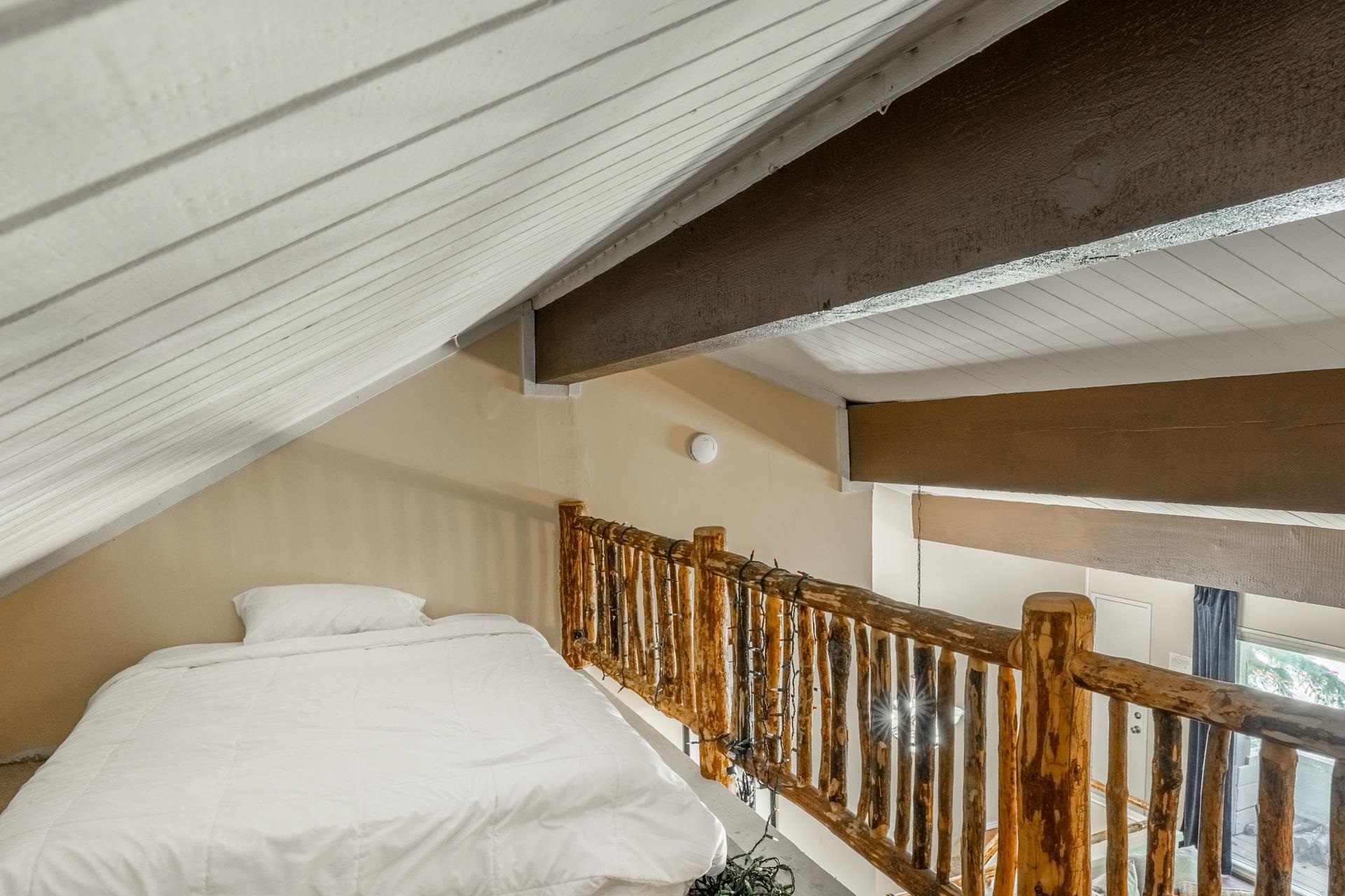 165 Old Mammoth Road, Unit 3 Mammoth Lakes, CA 93546 - Photo 34 of 48 Sloped planked ceiling with exposed beams, light tan walls, and a rustic wood railing