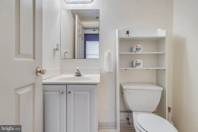 a bathroom with a toilet a sink and mirror