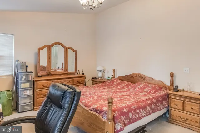 a bedroom with a bed dresser and a window