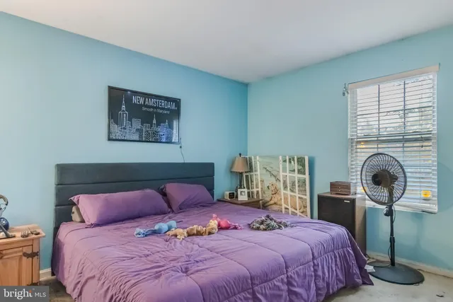 a bedroom with a bed and a flat tv screen on the dresser