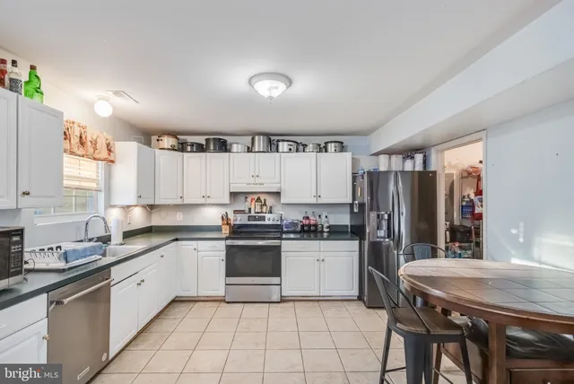 a kitchen with a sink a refrigerator and cabinets