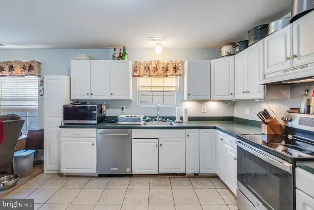 a kitchen with granite countertop appliances a sink and cabinets