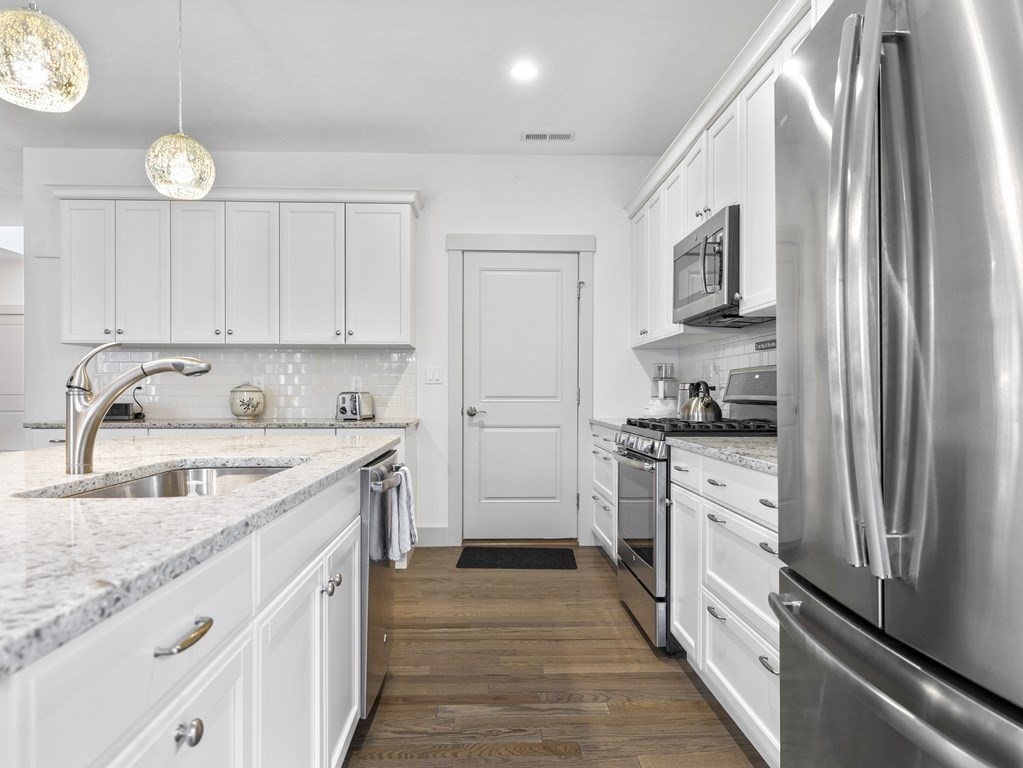 34 Lantern Way, Unit 34 Ashland, MA 01721 - Photo 4 of 30 a kitchen with granite countertop a refrigerator sink and white cabinets