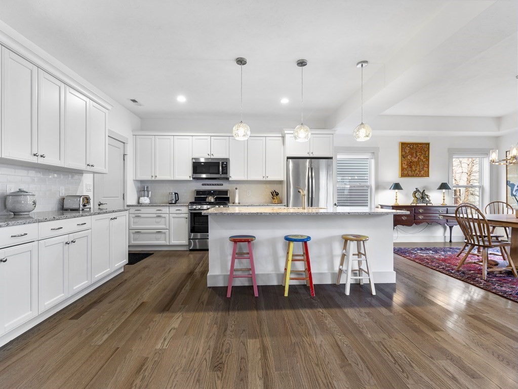 34 Lantern Way, Unit 34 Ashland, MA 01721 - Photo 5 of 30 a kitchen with stainless steel appliances granite countertop a stove top oven a sink dishwasher and white cabinets with wooden floor