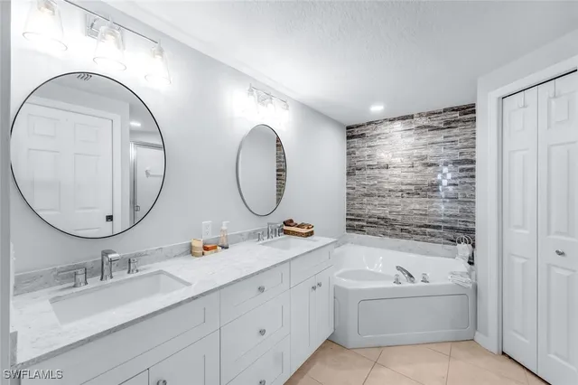 a en suite bathroom with a granite countertop tub sink and mirror