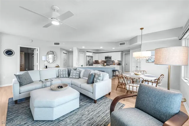 a living room with furniture kitchen view and a chandelier