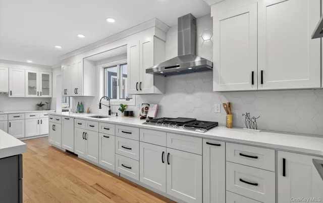 a kitchen with stainless steel appliances granite countertop a sink a stove and cabinets