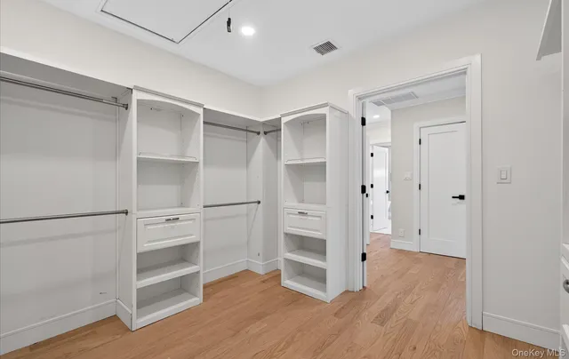 a view of walk in closet with wooden floor
